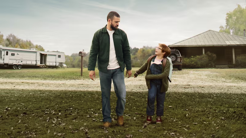 静かな田舎町で男性と少年が歩く姿を描いた映画『パーマー』のワンシーン