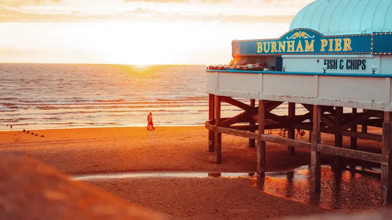 夕日に染まるイギリス・Burnham-on-Seaの海辺と、Fish & Chipsの看板があるBurnham Pier。