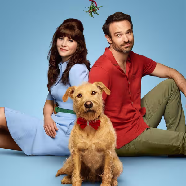 青い背景の前で、犬が中央に座り、その後ろにズーイー・でシャネルとチャーリー・コックスが腰掛けている様子の映画ポスター。