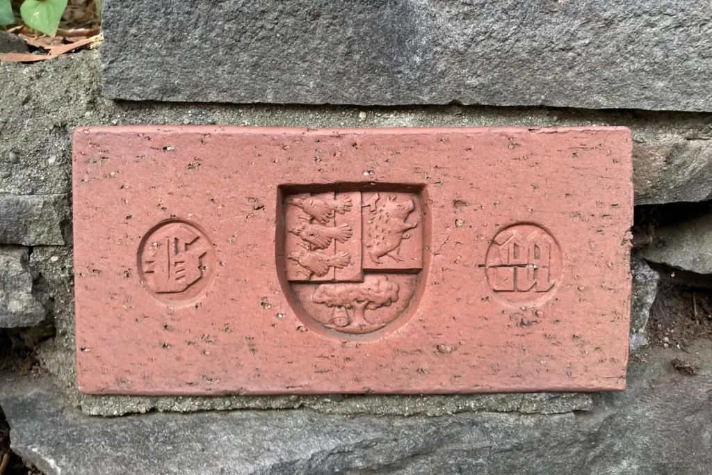 Brick plate with coat of arms embedded in the stone wall of the Ghibli Museum