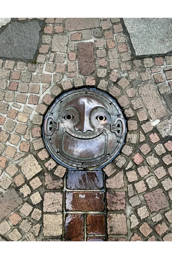 Manhole with face design on the grounds of the Ghibli Museum