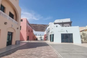 カラフルな布の屋根がかかるドーハの静かな通りとパステルカラーの建物