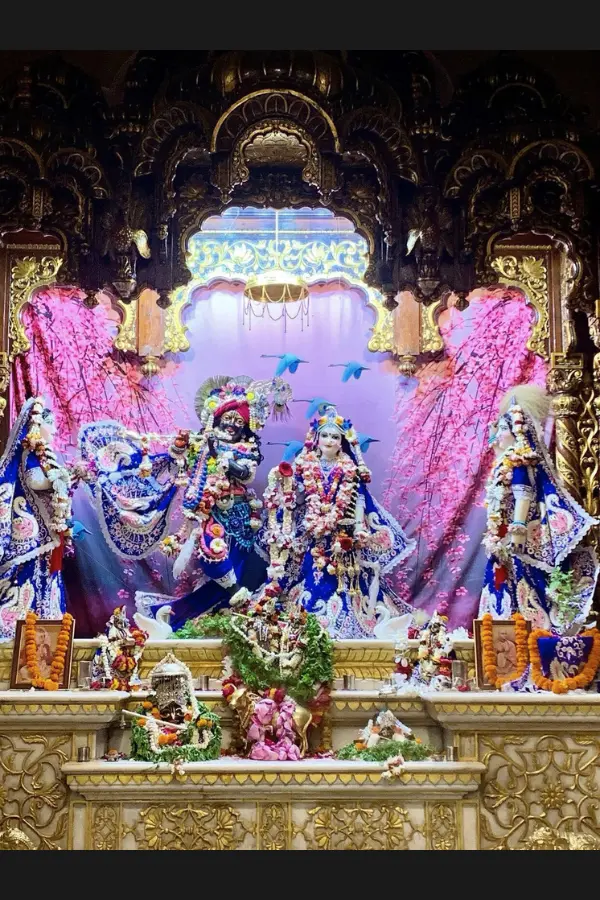 色鮮やかな装飾と花に囲まれたISKCON寺院の祭壇の様子