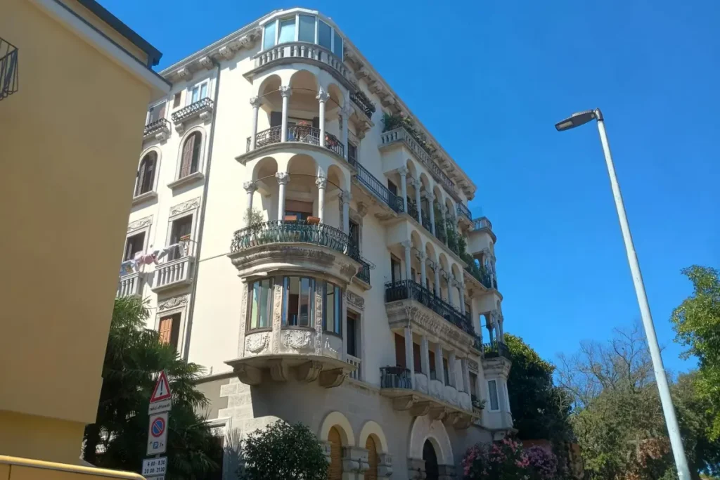 ヴェネツィア・リドの青空の下に立つ、装飾的なバルコニーが美しい集合住宅。
