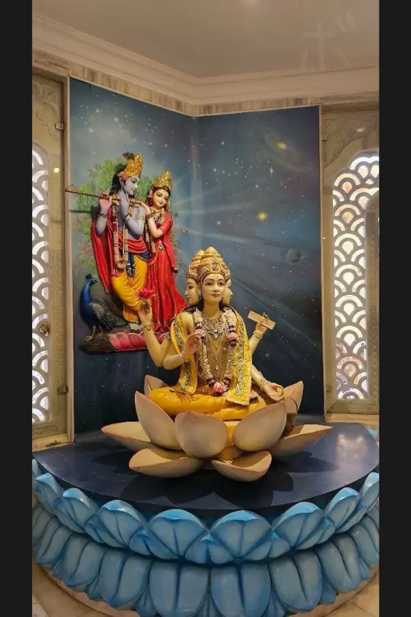 A Hindu deity statue sitting on a lotus and a quiet, sacred interior space
