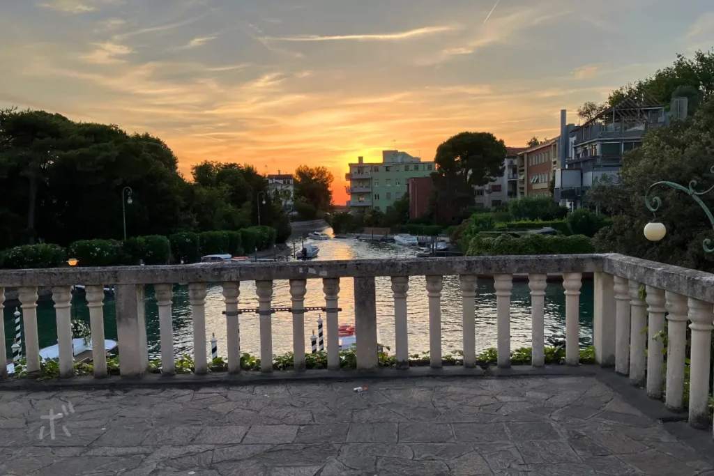 ヴェネツィア・リドの橋の上から見た、夕陽に染まる運河と石の欄干。