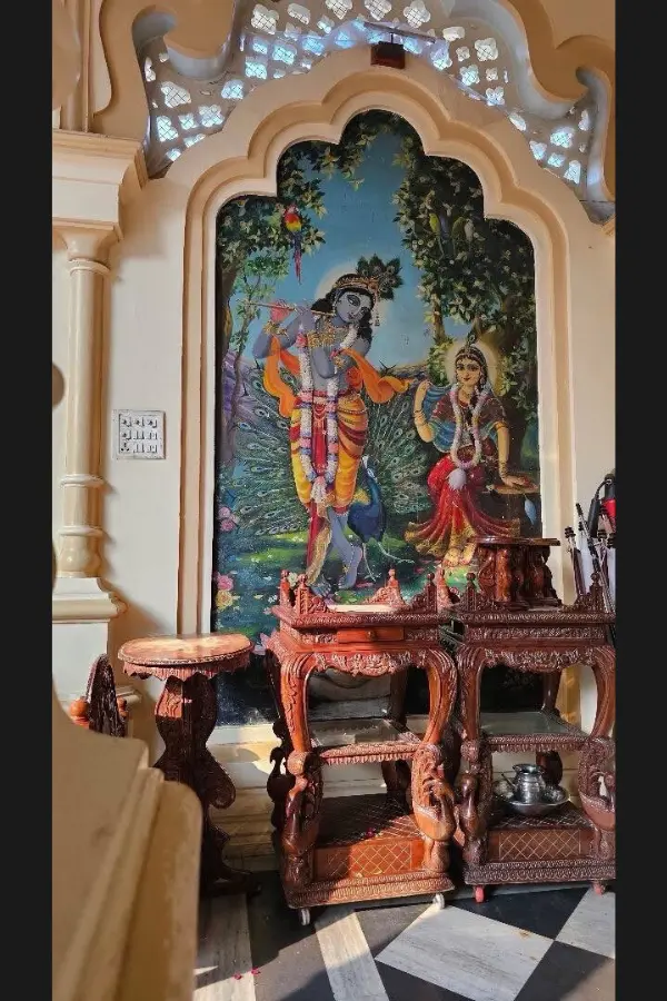 寺院の壁画と、精巧に彫られた木製家具が並ぶ室内の風景