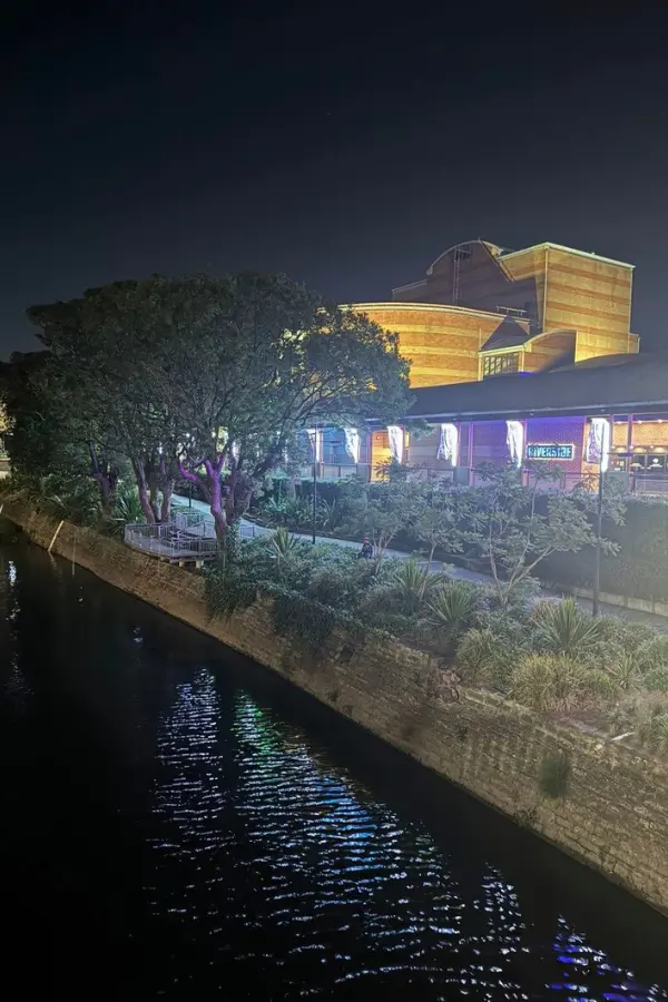 夜のParramatta川沿いに建つ劇場の建物が、灯りに照らされ水面に映り込んでいる様子。