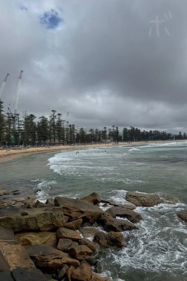 岩場と白波、曇り空が印象的なマンリー周辺の海辺の風景