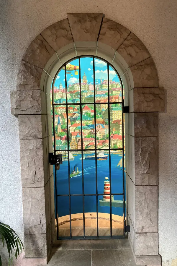 Brightly colored stained glass shines in the arched windows of the Ghibli Museum