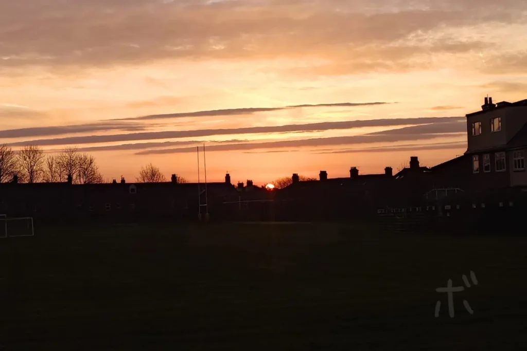 住宅街の向こうに沈む夕焼けと広がる空