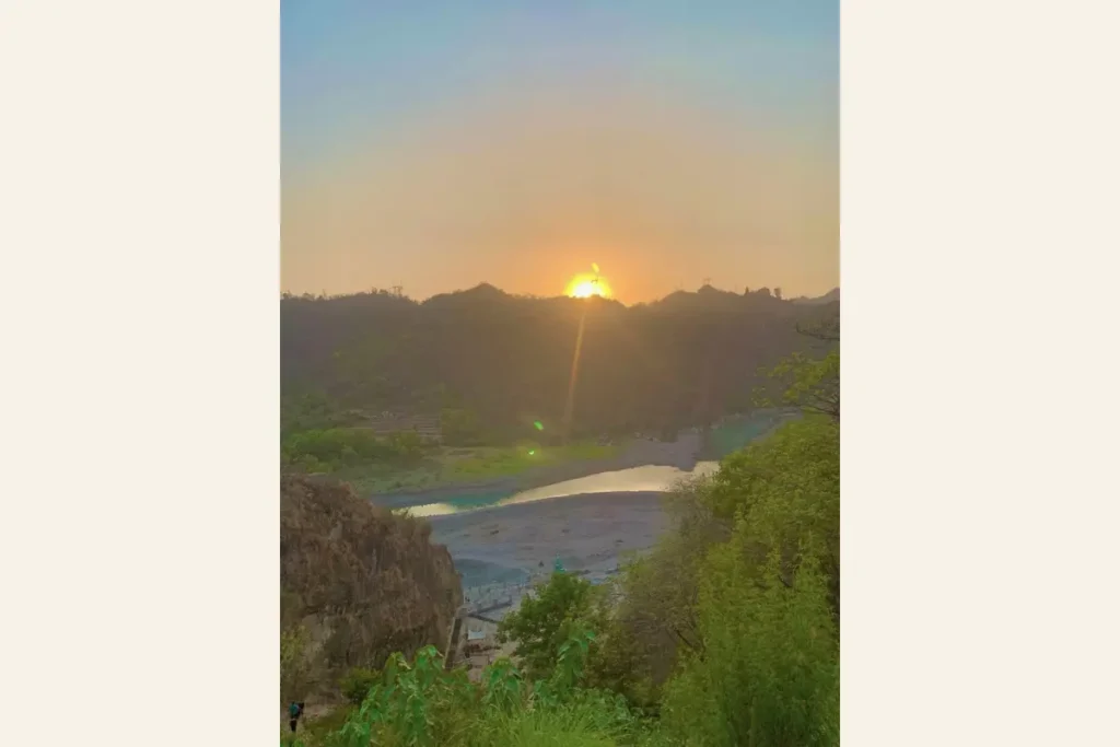A quiet sunset over rivers and mountains in India, where faith and everyday life gently coexist