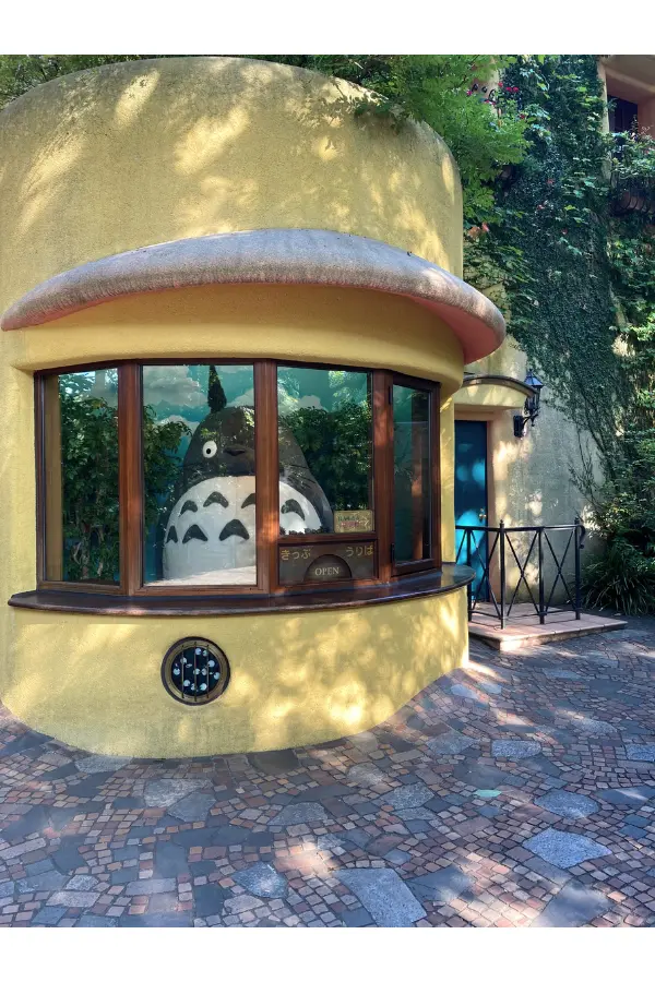Totoro standing at the reception desk of the Ghibli Museum.