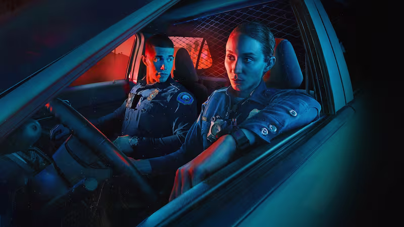 パトロール車内で無線対応中の2人の警察官が緊張感の中で対話する『On Call（オン・コール）』のメインビジュアル