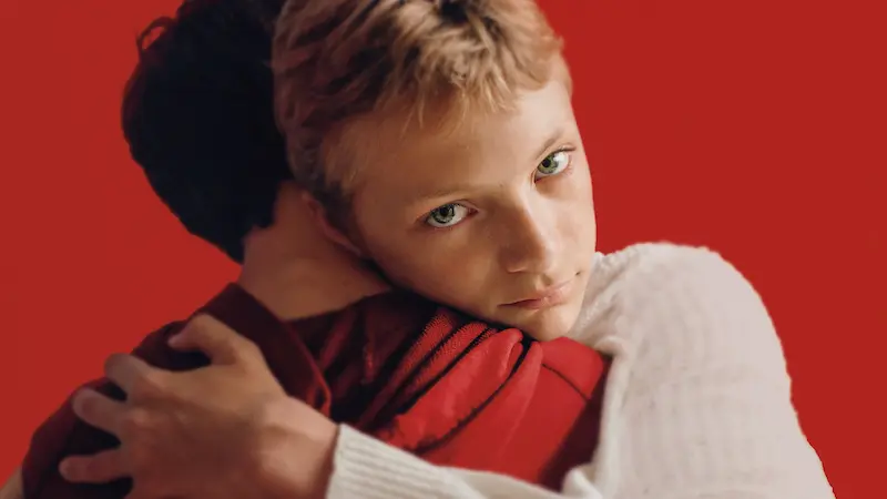 抱きしめ合う中で複雑な感情を抱えるレオの表情