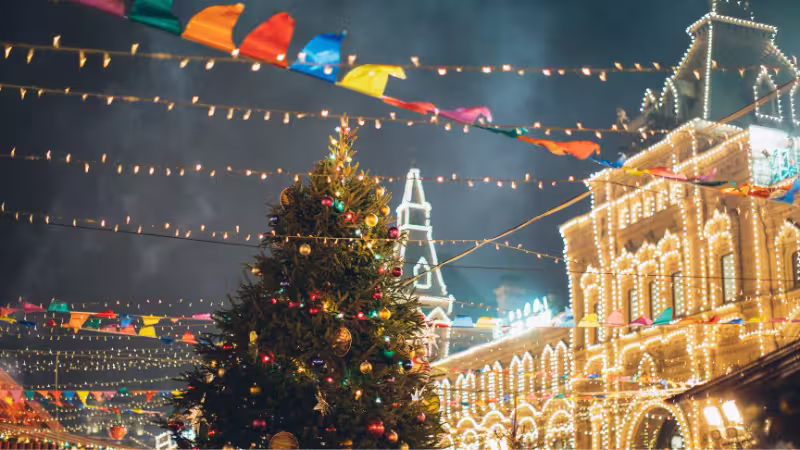 洋楽クリスマスソングの特集イメージ。街のライトとクリスマスツリーを背景に、海外のホリデーミュージックを紹介する画像。