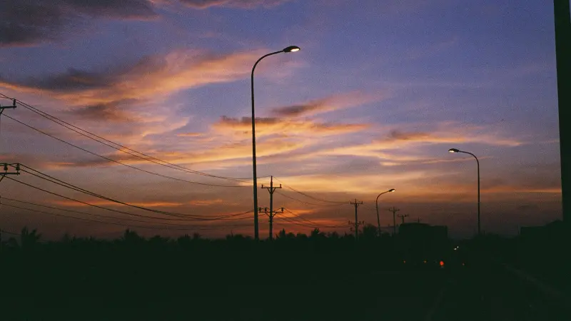 夕暮れの空と街灯が並ぶ道路風景。春の夕方や夜に聴きたいプレイリストをイメージした写真。