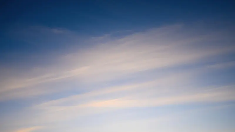 白っぽい春の青空と薄い雲。春に聴きたい曲やプレイリストの空気感を表現した風景写真。